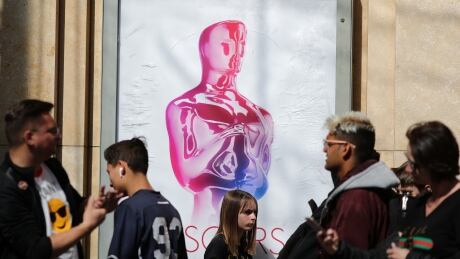 People walk past an Oscars poster as preparations continue for the 91st Academy Awards in Hollywood, Los Angeles, California, U.S., February 19, 2019. AWARDS-OSCARS/