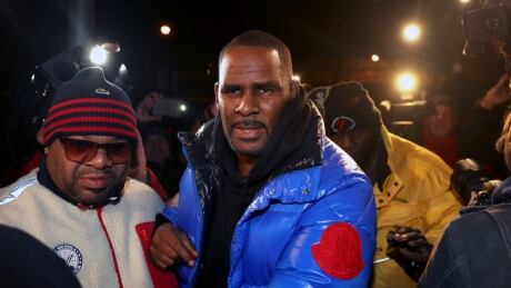 R. Kelly turns himself in at 1st District police headquarters in Chicago on Friday night, Feb. 22, 2019. R&B star R. Kelly arrived Friday night at a Chicago police precinct, hours after authorities announced multiple charges of aggravated sexual abuse involving four victims, including at least three between the ages of 13 and 17. APTOPIX R Kelly-Investigations
