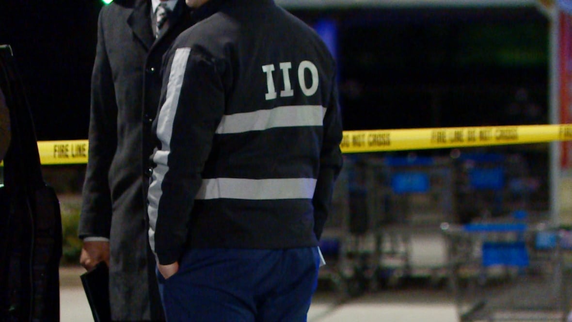 The back of a man wearing a jacket that says 'IIO' in reflective tape.