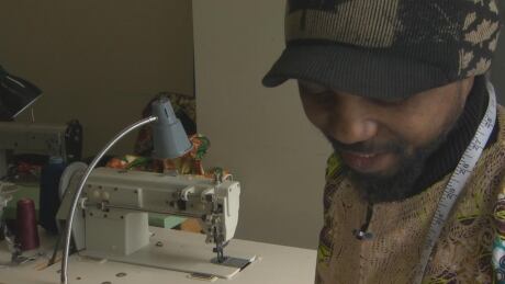 Safari Kabumbe works on a new design at his shop in the Guildford area of Surrey. Safari-Kabumbe-Sewing-Machine