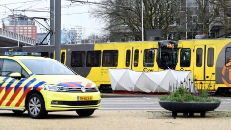 A barrier erected by police obscures the victims of a deadly tram shooting in the Dutch city of Utrecht this morning. Utrecht tram shooting