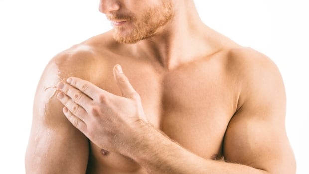 Man applies testosterone gel to his shoulder.