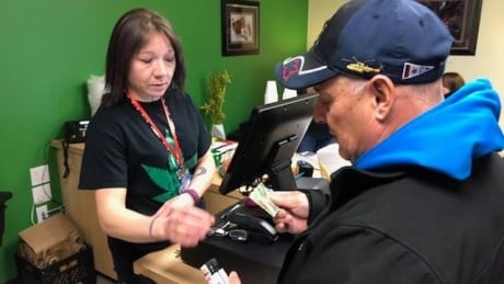 Aubrey Joe, right, makes the first purchase at the Miawpukek Cannabis Boutique in the Miawpukek First Nation. First Purchase Miawpukek Cannabis Boutique