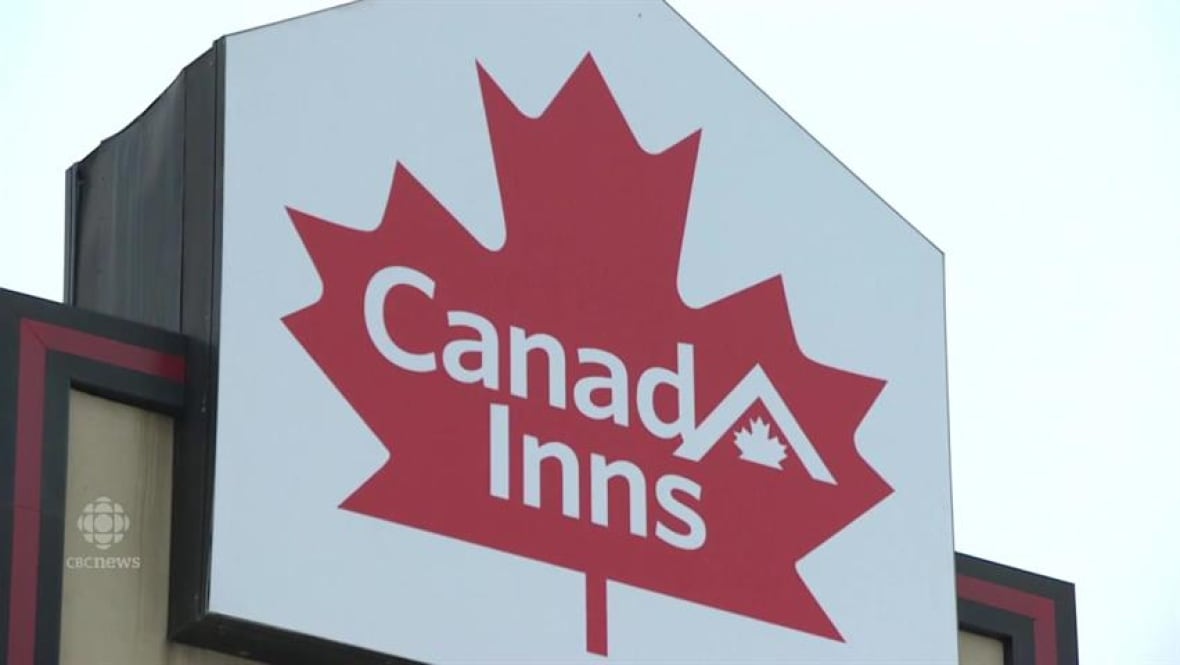 Pentagon-shaped sign with white background and red maple leaf with white writing inside reading "Canad Inns"