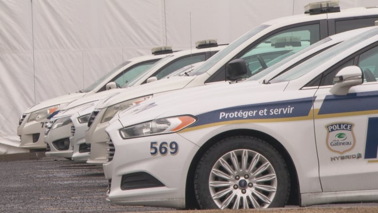 Five police vehicles parked in a lot.