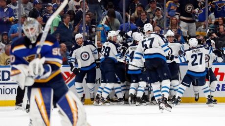 Winnipeg Jets celebrate as St. Louis Blues goaltender Jordan Binnington, left, skates to the bench after Jets left wing Kyle Connor scored during overtime in Game 4 on Tuesday. Jets-Blues