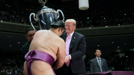 U.S. President Donald Trump presents the President’s Cup to wrestler Asanoyama, the winner of the Summer Grand Sumo Tournament at Ryogoku Kokigikan Sumo Hall in Tokyo, Japan May 26, 2019. REUTERS/Jonathan Ernst - RC1FA1A0AA70 JAPAN-USA/