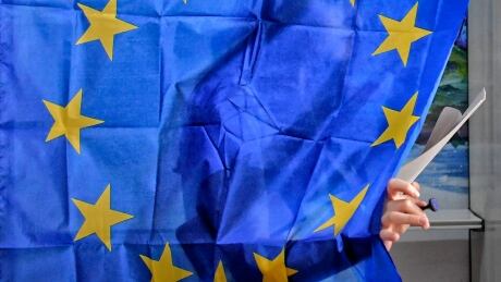 A woman exits a voting cabin with curtains depicting the European Union in Baleni, Romania, Sunday, May 26, 2019. The ruling Social Democratic Party (PSD) suffered a major blow in the European Parliament elections according to the country's only exit poll. (AP Photo/Andreea Alexandru) APTOPIX Romania European Elections