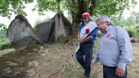 Chief Dalton Silver walks around Lightning Rock with Sonny McHalsie, Naxaxalhtsi, following a ceremony of Indigenous leaders in a call to save a First Nations burial site in Abbotsford, B.C., Friday, June 14, 2019. THE CANADIAN PRESS/Jonathan Hayward First Nations Burial Site Abbotsford