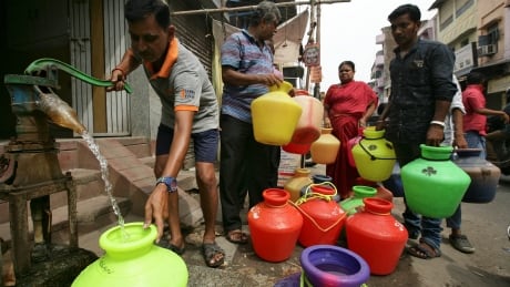 A man uses a hand-pump to fill up a container with drinking water as others wait in a queue on a street in Chennai, India, June 17, 2019. Picture taken June 17, 2019. INDIA-WEATHER/WATERCRISIS