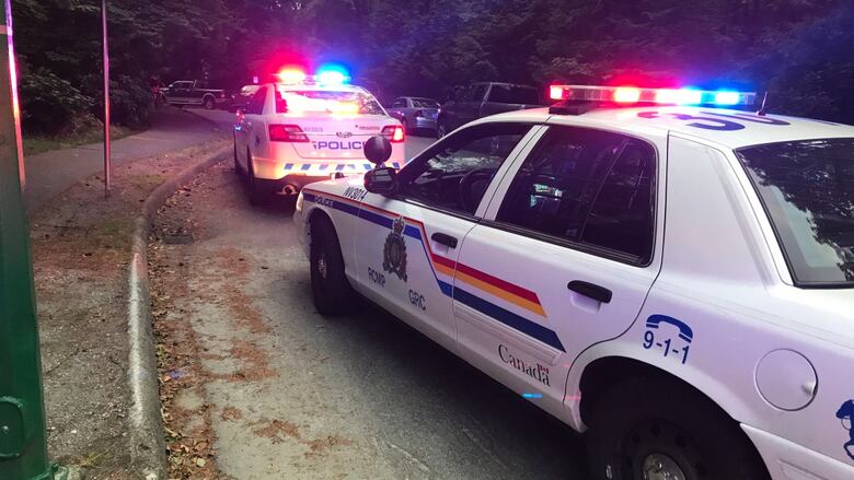 Two RCMP vehicles flash their lights