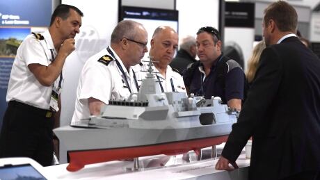 People surround a Bae Systems Type 26 Global Combat Ship at the Canadian Association of Defence and Security Industries CANSEC trade show in Ottawa on Wednesday, May 30, 2018. The federal government is being given the green light to award a contract for the design of the country's new $60-billion warships after a trade tribunal reversed course on an earlier order not to finish the deal. Navy Warships 20181211