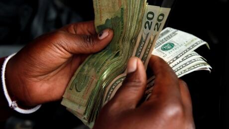 An illegal money changer counts dollar notes in Harare, Zimbabwe, January 10, 2019. REUTERS/Philimon Bulawayo - RC1827386890 ZIMBABWE-ECONOMY/STRIKE