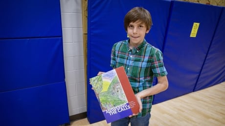 Grade 6 student Kalvin Keating with the book he and his classmates created on the Truth and Reconciliation Commission of Canada’s calls to action. Students showcased the book Monday night.
Grade 6 student Kalvin Keating with the book he and his classmates created on