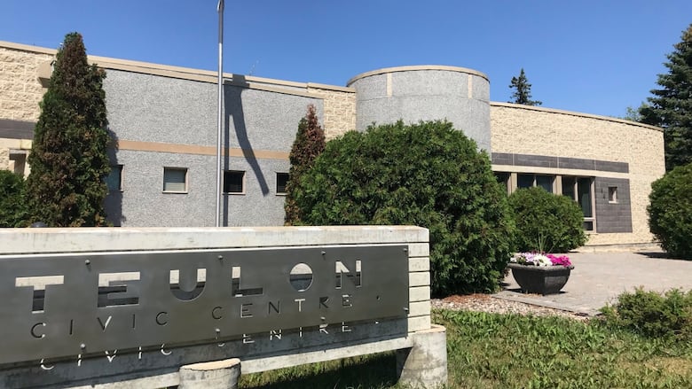 A sign says Teulon Civic Centre, with a flag on a flagpole and a building in the background.