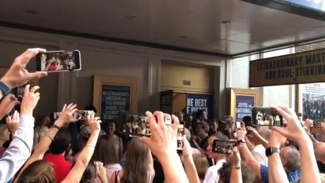 Fans hold up cell phones to record the cast of Come From Away putting off an impromptu version of Welcome to the Rock during a blackout in Manhattan. come from away