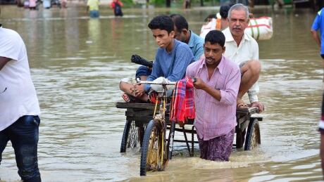 An Indian rickshaw puller transports commuters on a flooded street after a heavy downpour at Baldakhal village in Agartala, the capital of northeastern state of Tripura, on July 14, 2019. (Photo by Arindam DEY / AFP) (Photo credit should read ARINDAM DEY/AFP/Getty Images) 1155545698