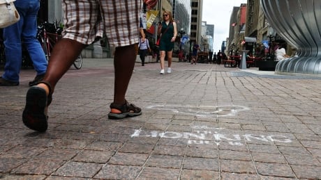 A man walks past a stencil on Sparks Street in Ottawa advertising Disney's remake of The Lion King on July 17, 2019. sparks street advertisement lion king disney ottawa