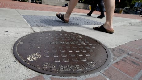 Pedestrians walk past a manhole cover for a sewer in Berkeley, Calif., Thursday, July 18, 2019. Soon students in Berkeley, California will have to pledge to "collegiate Greek system residences" instead of sororities or fraternities and city workers will have to refer to manholes as "maintenance holes." Officials in the liberal city this week passed an ordinance to replace some terms with gender-neutral words in the city code. Banned Words Berkeley