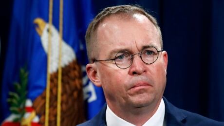 FILE- In this July 11, 2018, file photo Mick Mulvaney, listens during a news conference at the Department of Justice in Washington. Top White House aid Mick Mulvaney on Sunday, July 28, 2019 defended President Donald Trump's disparaging tweets about Rep. Elijah Cummings and his Baltimore district as a justified response to the lawmaker's criticism of administration border policies. Trump