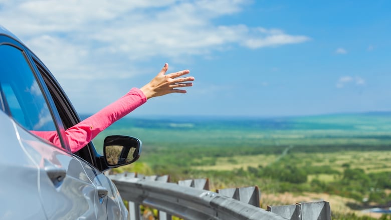 Happy female traveler with her hand out of car window feeling free. Road trip and on the road concept. (Location Hawaii); Shutterstock ID 524016745