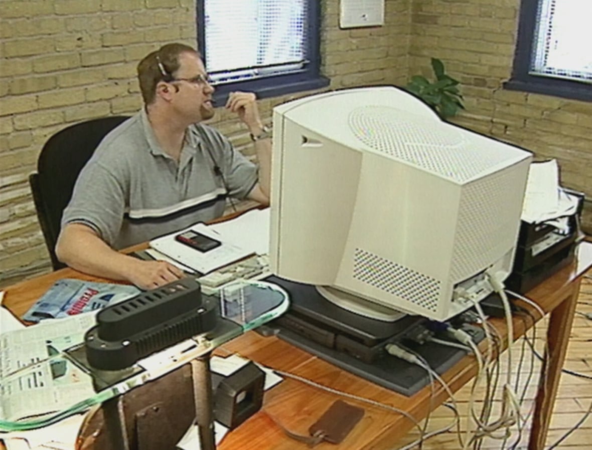 Man seated at blocky computer monitor