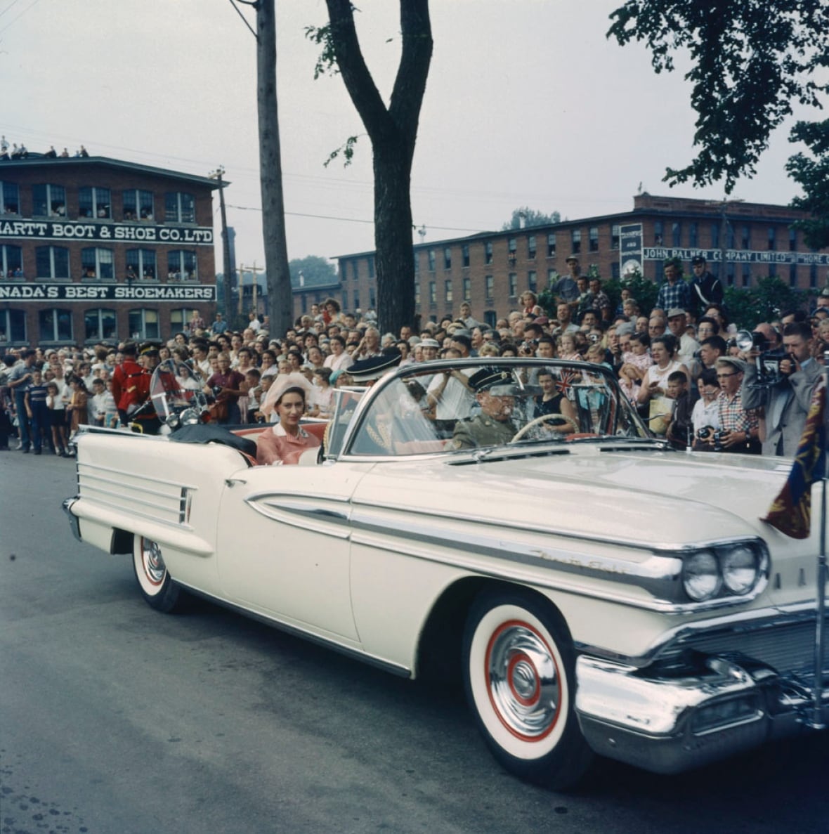 1950s car with fins surrounded by people looking on