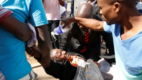 Bystanders assist a woman injured in Harare on Friday during clashes after police banned planned protests over austerity and rising living costs called by the opposition Movement for Democratic Change (MDC) party.
ZIMBABWE-POLITICS/
