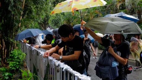 Pro-democracy protesters tie white-ribbons, symbolizing the pure intentions of young protesters during a march organized by teacher in Hong Kong Saturday, Aug. 17, 2019. China's paramilitary People's Armed Police marched and practiced crowd control tactics at a sports complex in Shenzhen across the border in Hong Kong on Friday, Aug. 16 in what some have interpreted as a threat against pro-democracy protesters. Hong Kong Protests