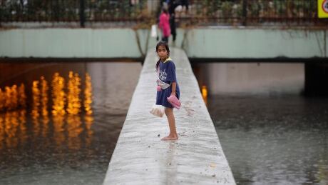 A barefooted girl stands on a flooded street following heavy rains in Istanbul, Turkey, August 17, 2019. TURKEY-WEATHER/