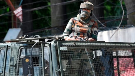 An Indian army soldier stands alert in a truck while travelling in a convoy in Srinagar on August 18, 2019. - Thousands of people have been detained in Indian Kashmir over fears of unrest since New Delhi stripped the restive region of its autonomy two weeks ago, government sources told AFP. A magistrate speaking to AFP on condition of anonymity said at least 4,000 people were arrested and held under the Public Safety Act (PSA), a controversial law that allows authorities to imprison someone for up to two years without charge or trial. (Photo by Punit PARANJPE / AFP) (Photo credit should read PUNIT PARANJPE/AFP/Getty Images) 1162364396