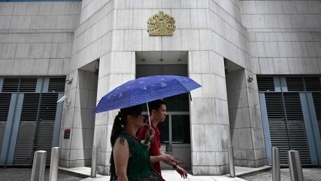 Pedestrians walk past the British Consulate-General building in Hong Kong on August 20, 2019. - Britain's Foreign Office said on August 20, it was "extremely concerned" by reports that a Hong Kong consulate employee had been detained by mainland Chinese authorities on his way back to the city. (Photo by Anthony WALLACE / AFP) (Photo credit should read ANTHONY WALLACE/AFP/Getty Images) 1162844073