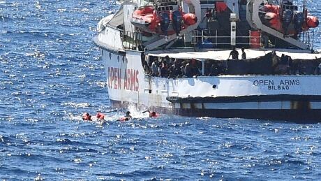 Migrants swim after jumping off the Spanish rescue ship Open Arms, close to the Italian shore in Lampedusa. EUROPE-MIGRANTS/ITALY-SPAIN