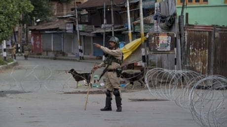 An Indian paramilitary soldier gestures towards a Kashmiri man as he orders him to turn back during lockdown in Srinagar, Indian controlled Kashmir, Sunday, Aug. 18, 2019. (AP Photo/ Dar Yasin) India Kashmir