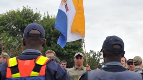 South Africans supporting the white supremacist Afrikaner Resistance Movement (AWB) fly the apartheid-era flag in 2010 outside a South African court in the northwestern town of Ventersdorp. 98277424