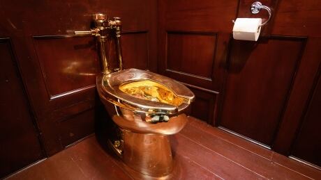 WOODSTOCK, ENGLAND - SEPTEMBER 12: "America", a fully-working solid gold toilet, created by artist Maurizio Cattelan, is seen at Blenheim Palace on September 12, 2019 in Woodstock, England. The Italian artist is known as the prankster of the art world. His most notable piece being "America" a solid gold usable toilet which had art lovers queuing to use when it was shown at the Guggenheim Museum in New York. (Photo by Leon Neal/Getty Images) America