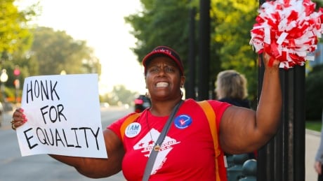 Statehood activist Darrah Baldwin holds a sign asking passing people driving past Capitol Hill to honk in support of D.C. becoming the 51st state. Darrah Baldwin