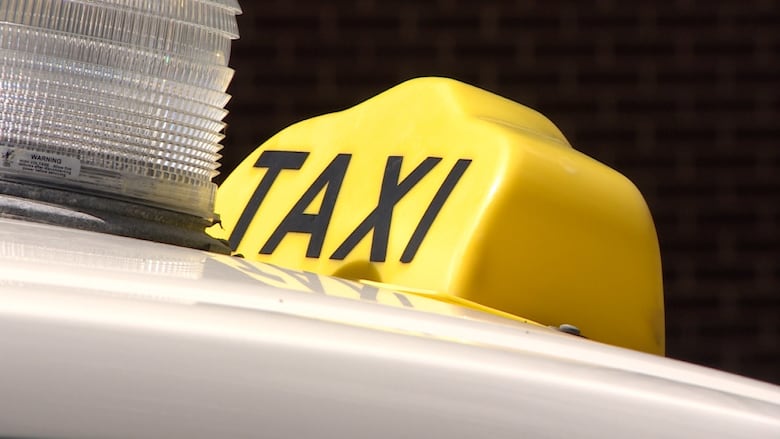 A closeup shows a taxi sign and the cab's emergency light.