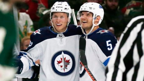 Winnipeg Jets defenseman Nelson Nogier (62) is congratulated by defenseman Dmitry Kulikov (5) after scoring a goal against the Minnesota Wild during the first period of a preseason NHL hockey game Wednesday, Sept. 26, 2018, in St. Paul, Minn. The Winnipeg Jets have signed defenceman Nelson Nogier to a one-year, two-way contract with an average annual value of US$700,000. HKN Jets Nogier 20190716