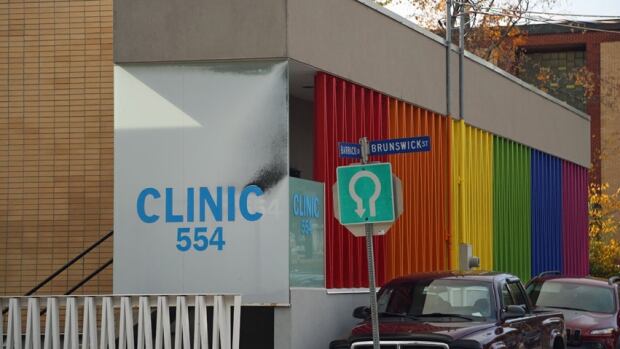 A majority helps Higgs avoid even symbolic defeats. On Thursday, for example, the PC majority was able to gut a motion demanding that surgical abortions at Clinic 554 be funded by Medicare. A brick one-storey building has a large rainbow sign painted on the side.