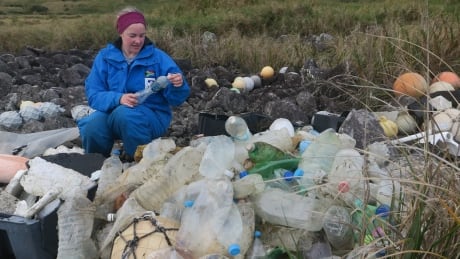 This is Maelle Connan, a member of the research team, checking bottles washed ashore on Inaccessible Island for manufacturers' marks to determine when and where the bottles were made. Bottles washed ashore
