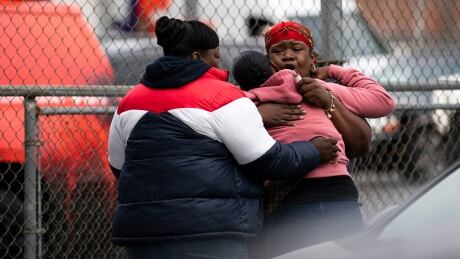 People embrace at the scene of a shooting in the Brooklyn borough of New York on Saturday, Oct. 12, 2019. Police were investigating Sunday whether a gambling dispute, robbery or something else led to the shooting deaths of several people at an illegal gambling club in Brooklyn that was just blocks from a police precinct. APTOPIX Brooklyn Shooting