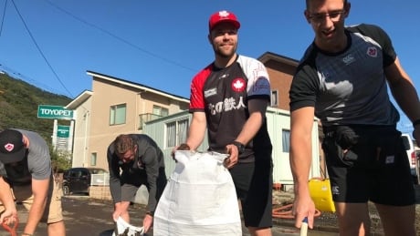 Members of Team Canada cleaning mud out of the streets of Kamaishi, Japan. Rugby World Cup