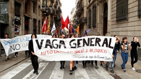Catalan demonstrators, in Barcelona, Spain, hold a banner which reads 'General strike' on Friday. Hundreds of thousands have taken to the streets in protest after nine separatist leaders were sentenced over their roles in the failed 2017 referendum on independence. SPAIN-POLITICS/CATALONIA-STRIKE