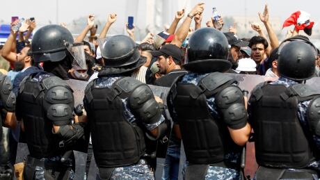 Iraqi security forces stand guard as demonstrators take part in a protest over unemployment, corruption and poor public services, in Baghdad, Iraq. The UN said Wednesday that authorities committed serious human rights violations in their response to a protests earlier this month that saw 149 civilians killed, IRAQ-PROTEST/