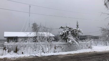 A downed power line hangs over the front yard of a home following a weekend snowstorm that knocked out power to thousands in Pimicikamak Cree Nation and Cross Lake. downed power line Pimicikamak Cree Nation