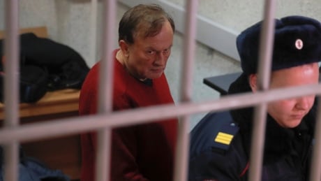 Russian historian and professor Oleg Sokolov, who is accused of murdering his girl friend and former student, is escorted inside a court building in Saint Petersburg, Russia, on Monday. RUSSIA-MURDER/HISTORIAN