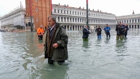 The Mayor of Venice Luigi Brugnaro walks on St Mark's Square during an exceptionally high water levels on Wednesday. ITALY-WEATHER/