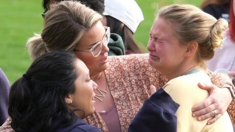 Students are comforted as they wait to be reunited with their parents following a shooting at Saugus High School that injured several people, Thursday, Nov. 14, 2019, in Santa Clarita, Calif. (AP Photo/Ringo H.W. Chiu) California High School Shooting
