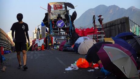 A protester walks across a barricaded bridge as traffic passes underneath near the Chinese University of Hong Kong in Hong Kong, Friday, Nov. 15, 2019. Protesters who had barricaded themselves in a Hong Kong university this week began to leave Friday after partially clearing a road they had blocked and demanding that the government commit to going ahead with local elections on Nov. 24. Hong Kong Protests